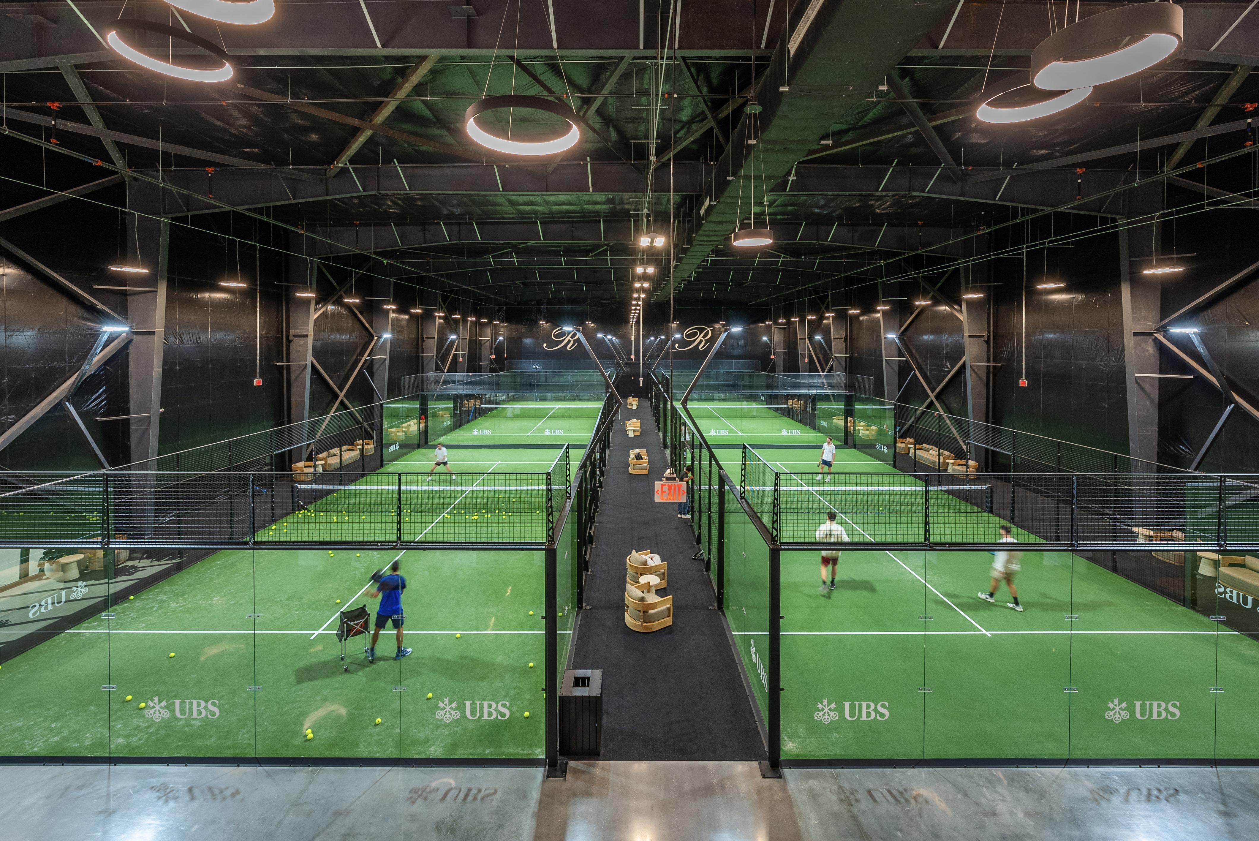 A tennis court with players and a net.